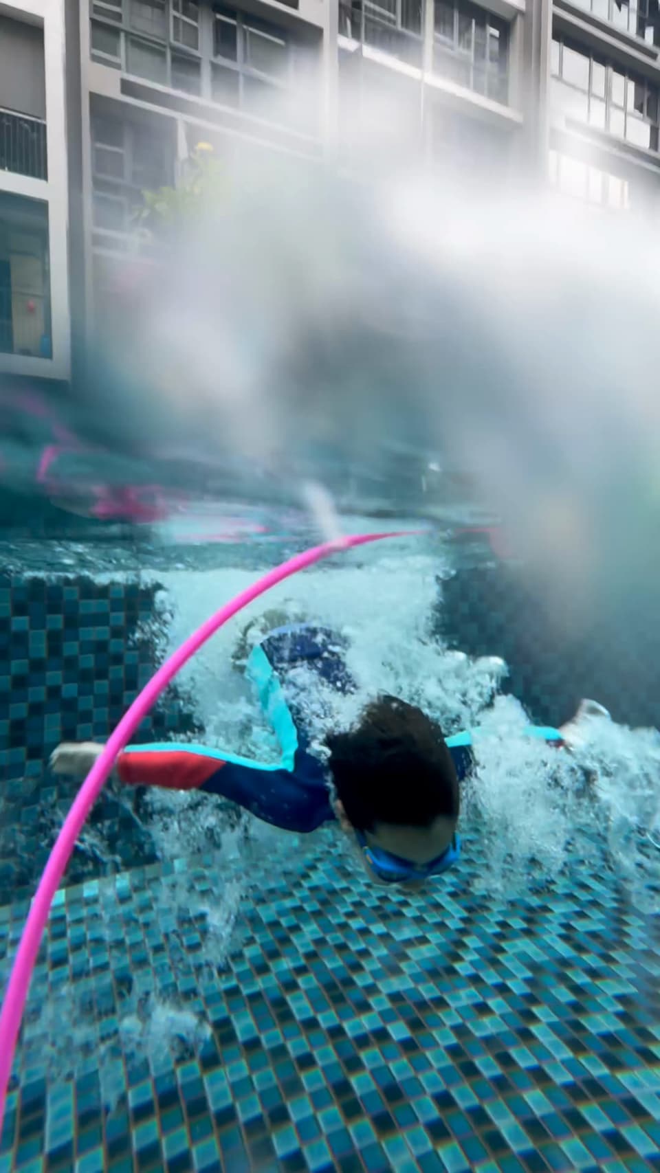 A child diving through a hoop underwater during a lesson